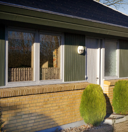 hus med lette traepartier mellem vinduerne